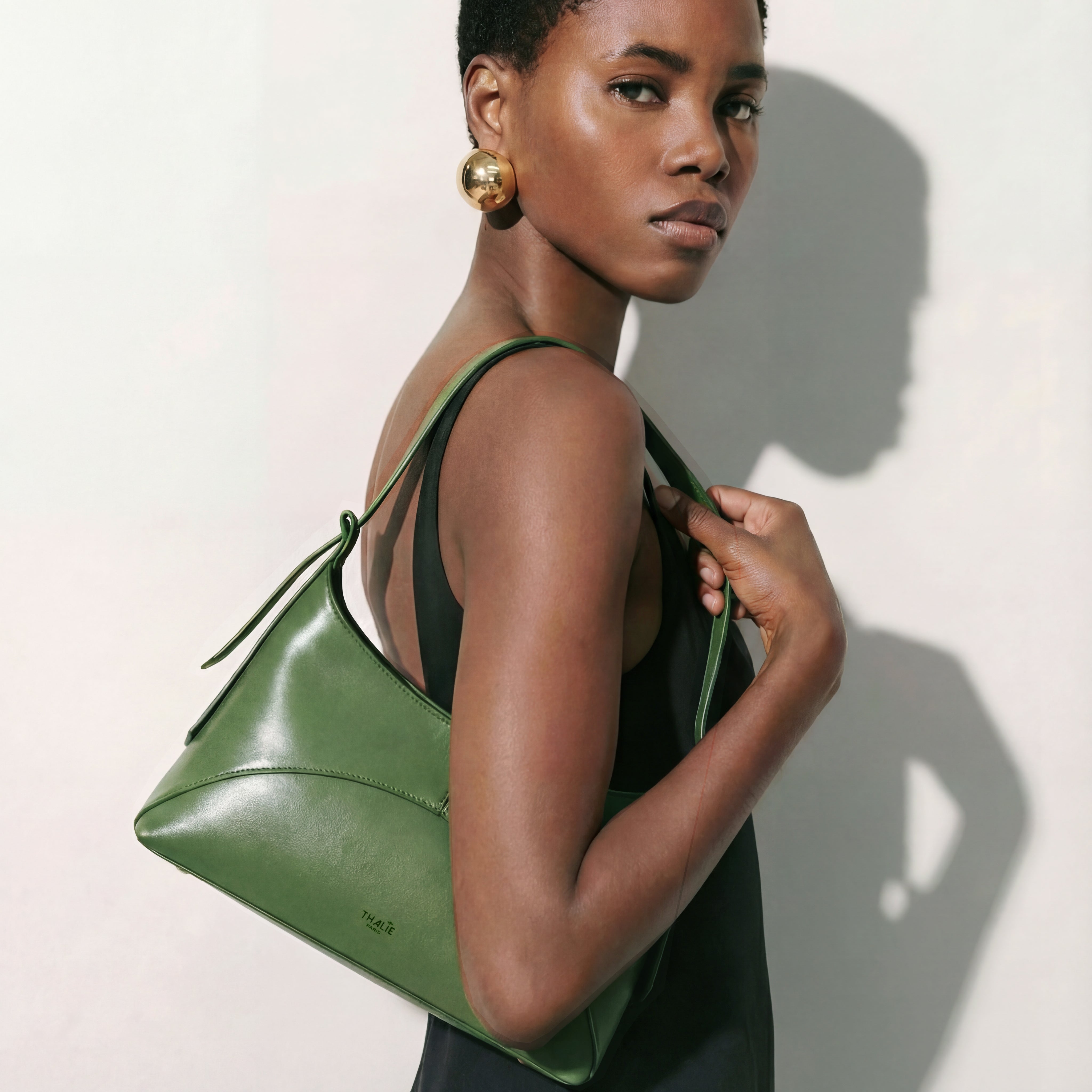 Model wearing the Ambre cactus green vegan shoulder bag by Thalie Paris, crafted from sustainable cactus leather with a minimalist Parisian design