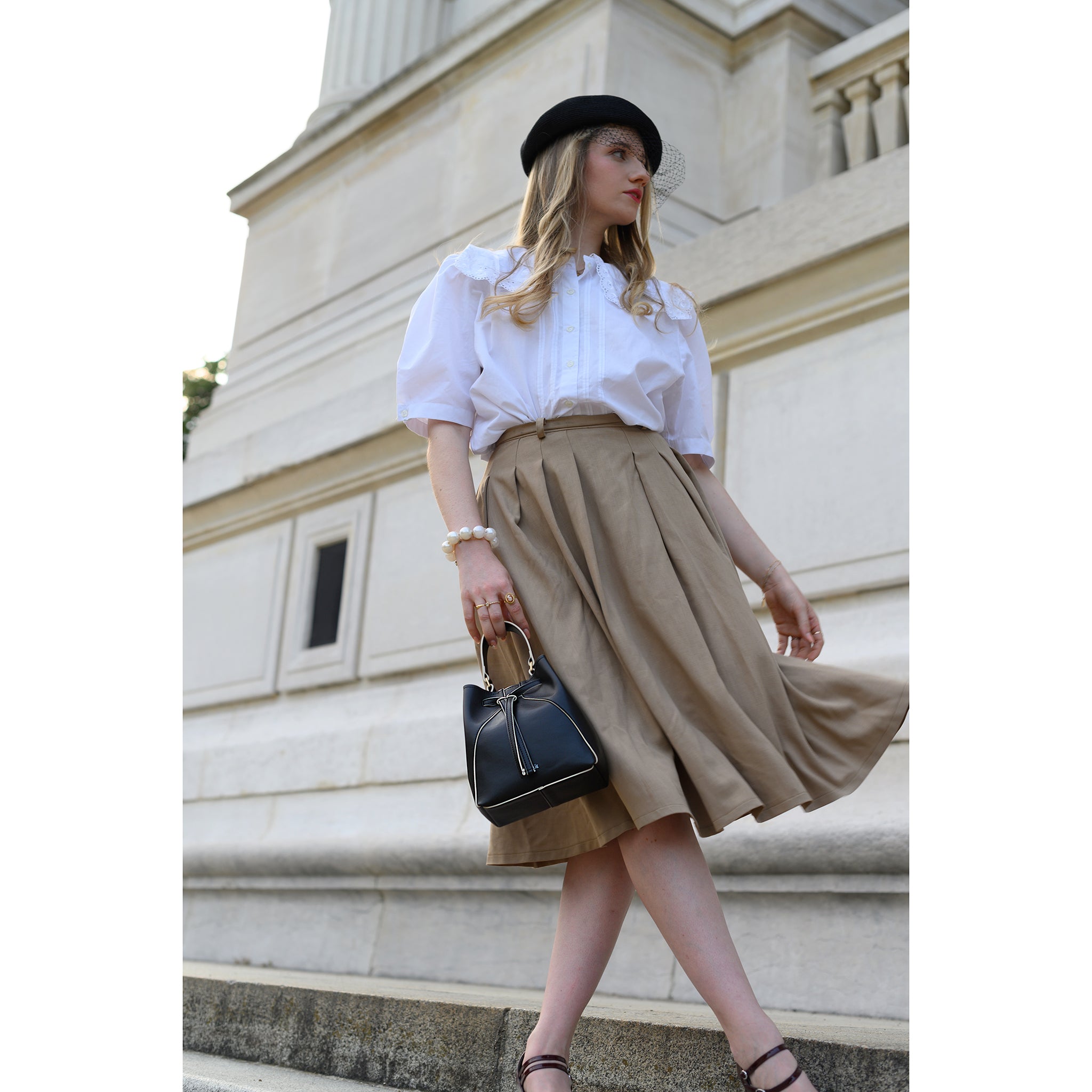 Model carrying Mia Black Bucket Bag a sophisticated accessory for any outfit. Thalie Paris