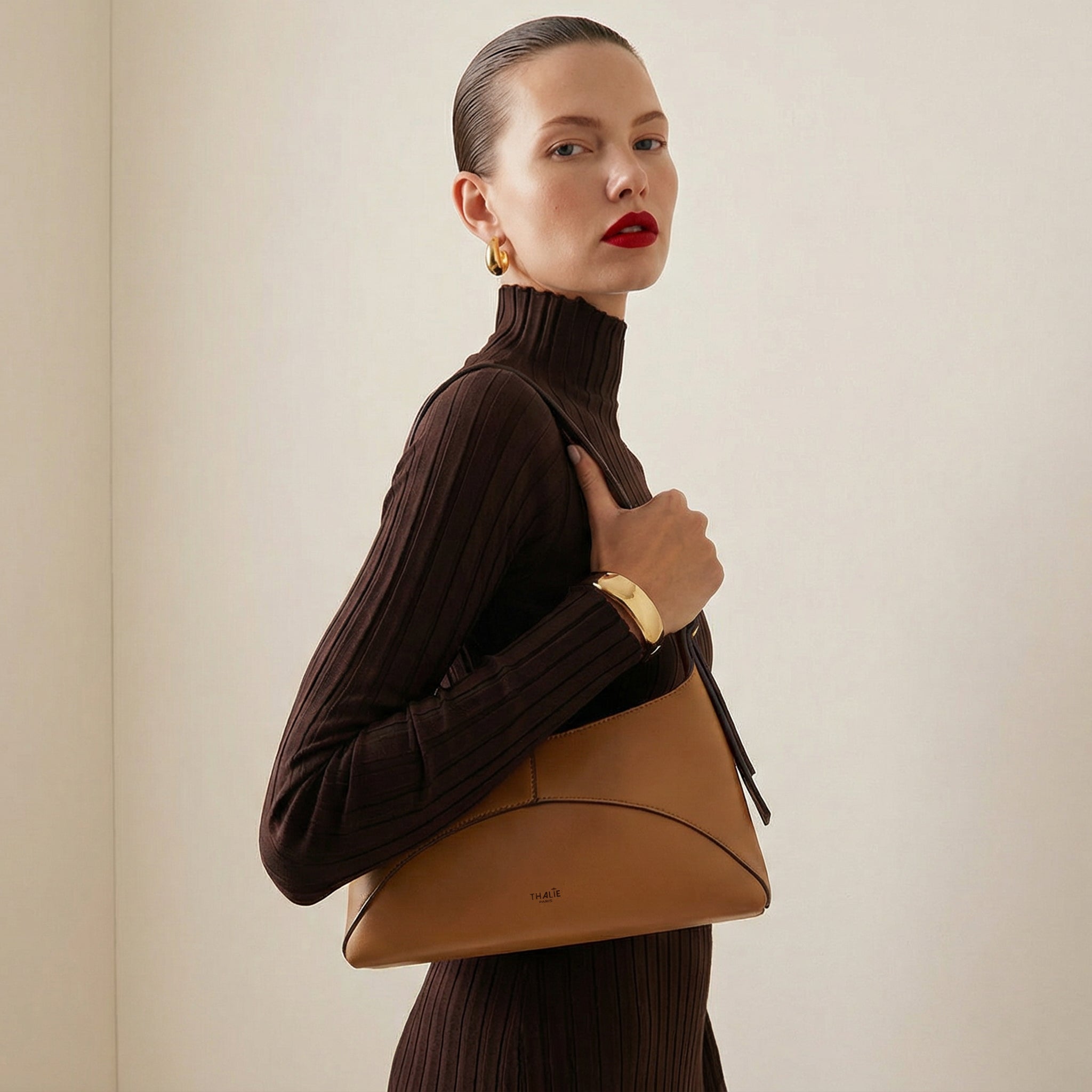 Front view of the Ambre vegan bag in tan by Thalie Paris, made from cactus-based leather alternative, featuring a refined curved silhouette and elegant shoulder strap.