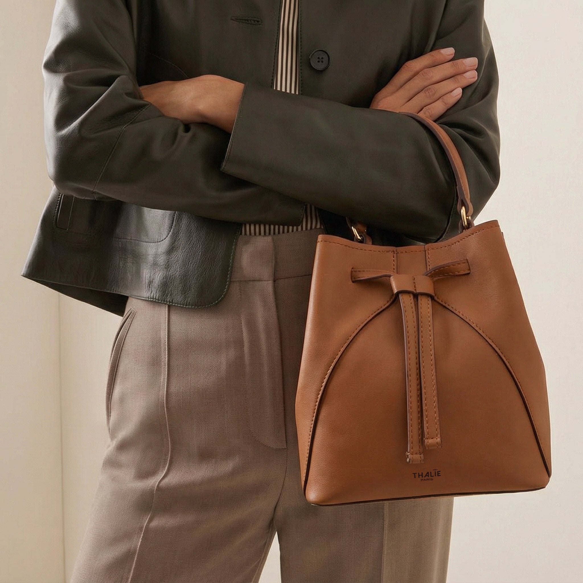 Close-up of the Mia vegan bucket bag in tan by Thalie Paris, crafted from plant-based cactus leather, carried by hand with a structured silhouette and top handle
