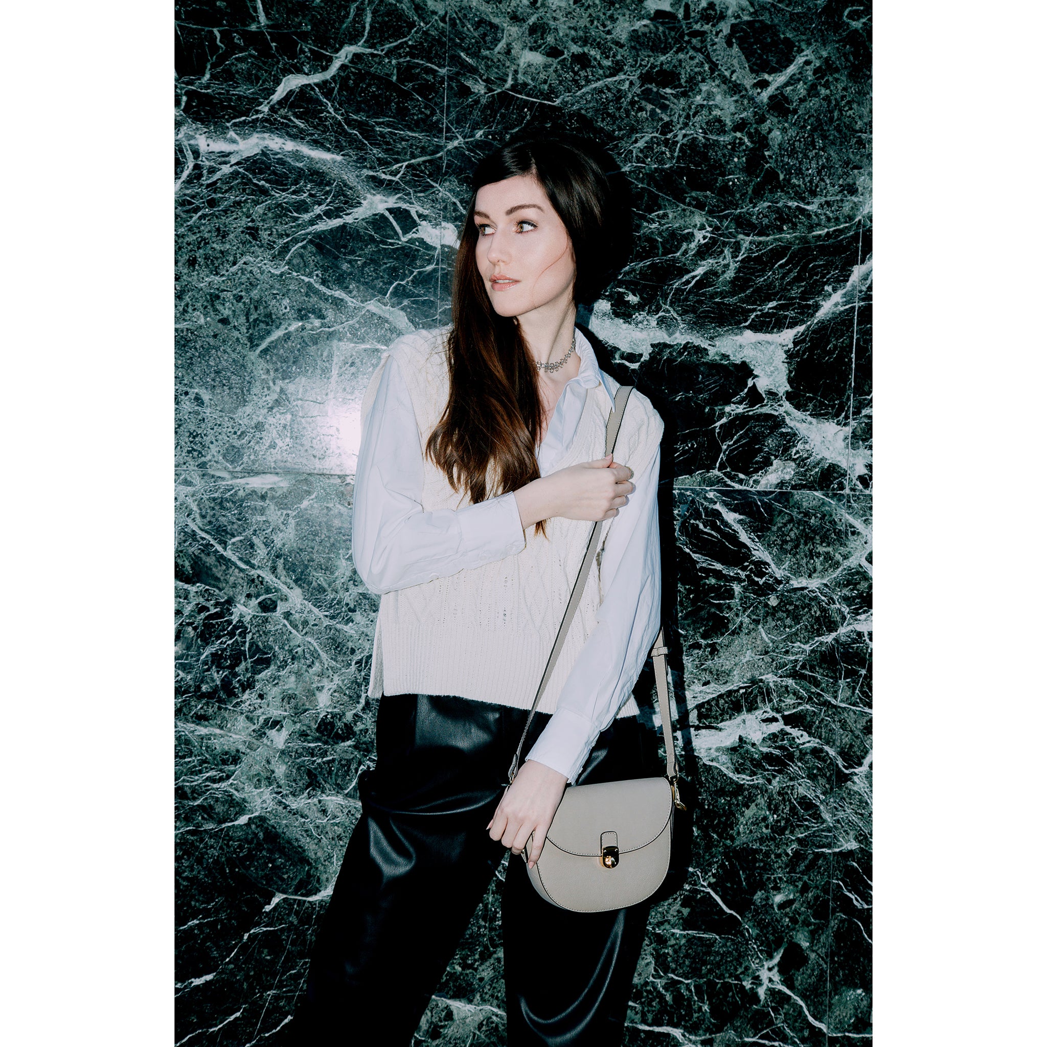 A model carrying the Florine beige vegan crossbody bag by Thalie Paris, embodying elegance and sustainability for any occasion.